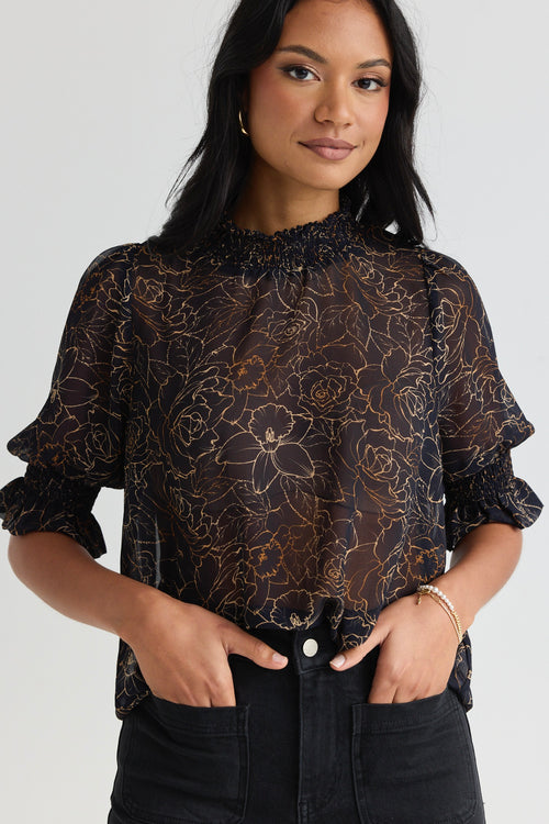 model wears a black floral blouse