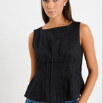 Woman wearing a black pintuck top with blue jeans