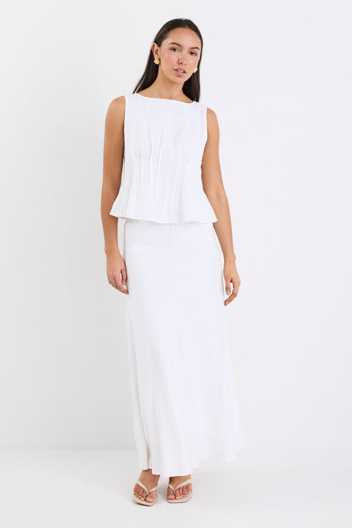 model wearing white top and white skirt