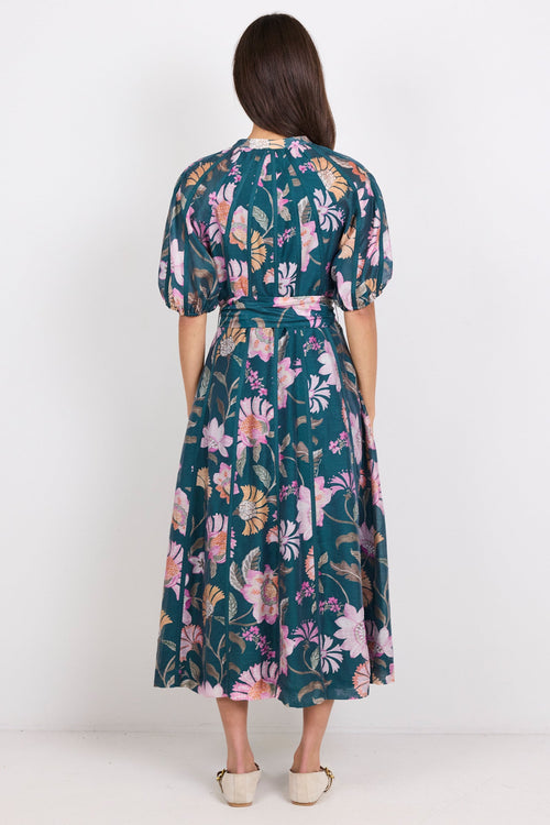 Woman wearing a floral dress with puff sleeves on a white background