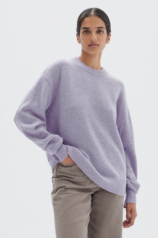 model wears a purple knit jumper