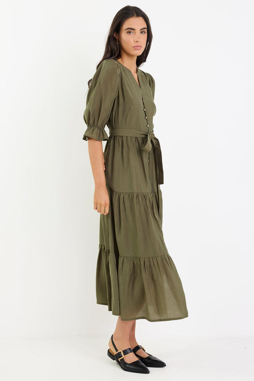 Woman wearing an olive green dress on a white background