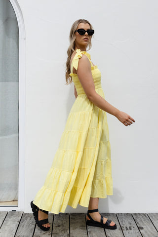model wearing long yellow maxi dress and black strappy sandals