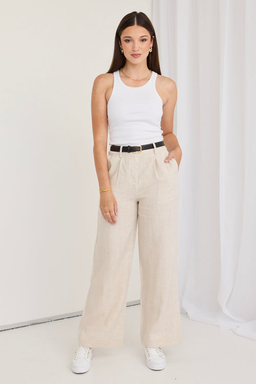 model wears natural linen pants and a white tank