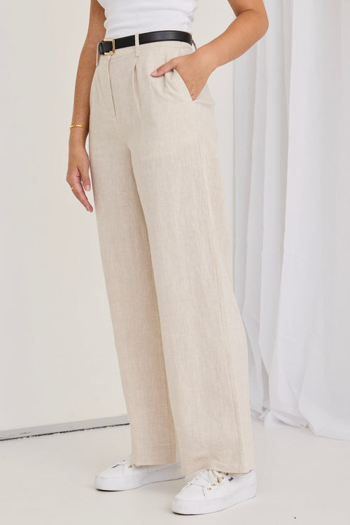 model wears natural linen pants and a white tank