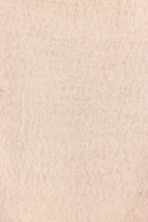 A close-up texture shot of a warm cream or off-white felted wool fabric, showing its soft, fibrous surface.