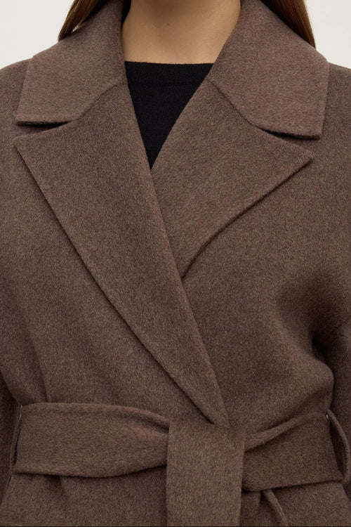 Brown coat worn by a person on a white background