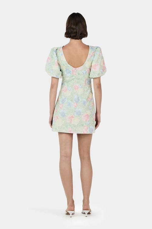 Woman wearing a green floral mini dress