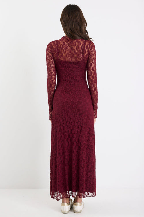 Woman wearing a burgundy lace dress on a white background