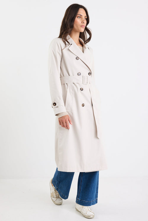 Woman wearing a long white coat on a white background