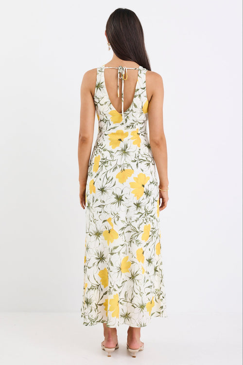 Woman wearing a floral dress with yellow flowers on a white background