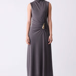 Woman wearing a sleeveless gray dress with a gold belt on a white background