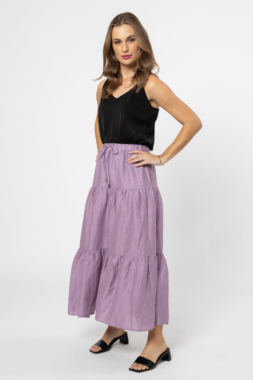 model wears a purple skirt with black top