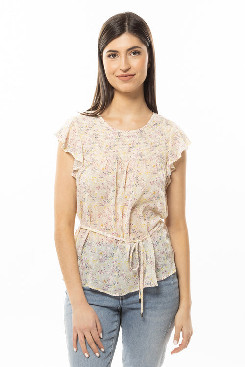 model wears a white floral top with jeans