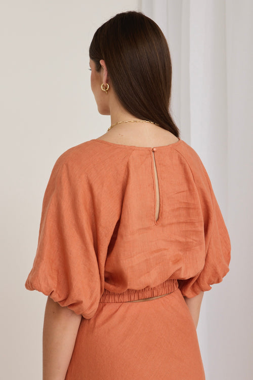 model wears a orange linen top