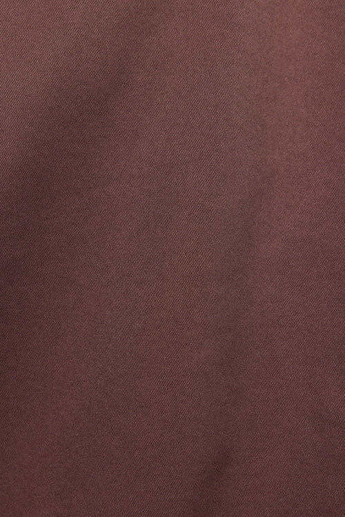 A close-up of a textured fabric in a muted, dusty rose-brown color.