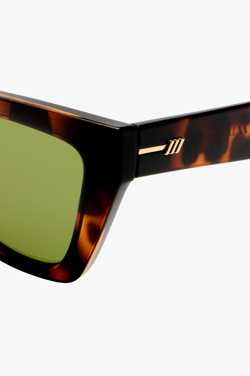 Dark tortoiseshell cat-eye sunglasses with angular frames and moss green lenses