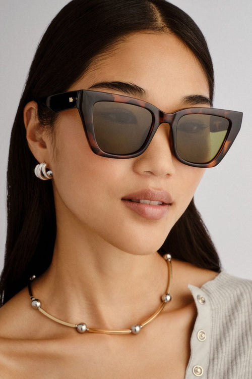 Dark tortoiseshell cat-eye sunglasses with angular frames and moss green lenses