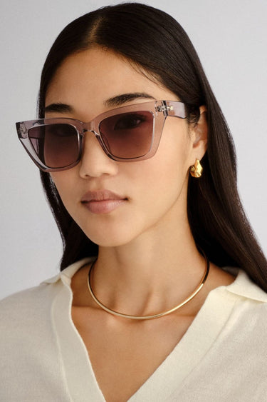 Transparent square cat-eye sunglasses with smoke gradient lenses.