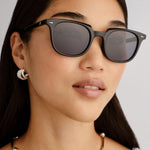 Black rounded sunglasses with smoke-tinted polarized lenses, shown front-facing on a white background.