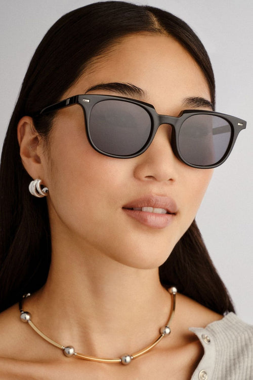 Black rounded sunglasses with smoke-tinted polarized lenses, shown front-facing on a white background.