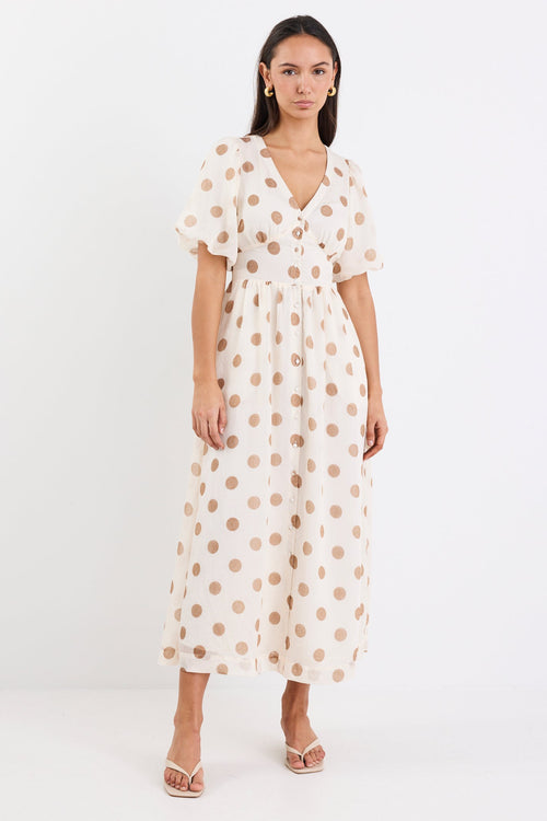 Woman wearing a cream brown polka dot maxi dress