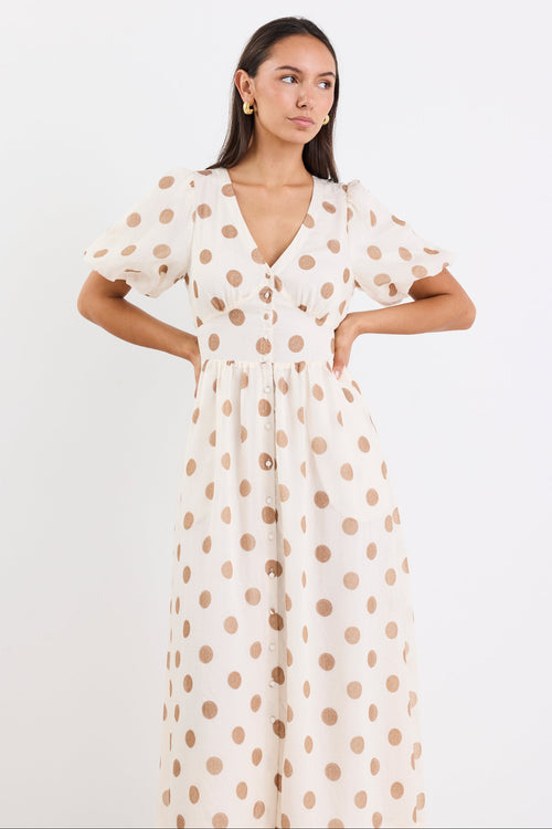Woman wearing a cream brown polka dot maxi dress