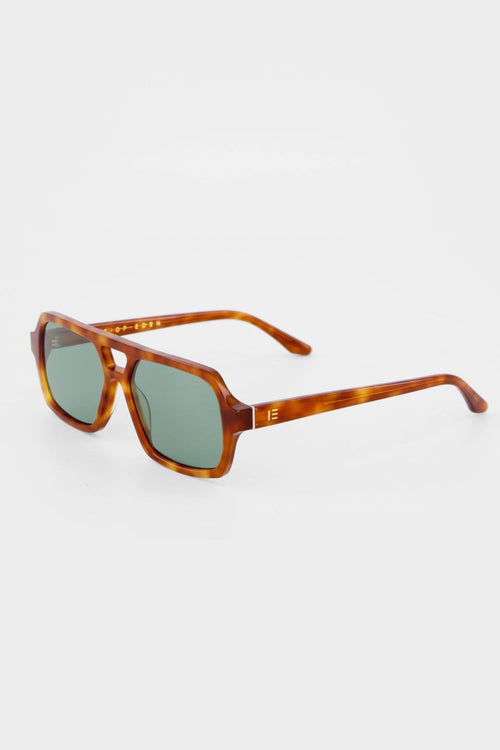 Honey tortoise aviator-style sunglasses with angular frames and green-tinted lenses.
