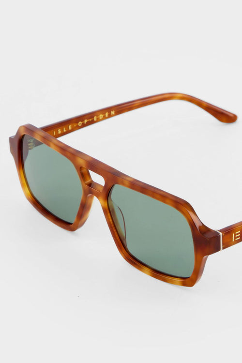 Honey tortoise aviator-style sunglasses with angular frames and green-tinted lenses.