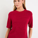 Model wearing a cherry red short sleeve knit tee with a crew neckline and side splits.