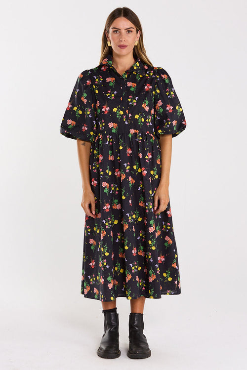 Woman wearing a black floral dress on a white background