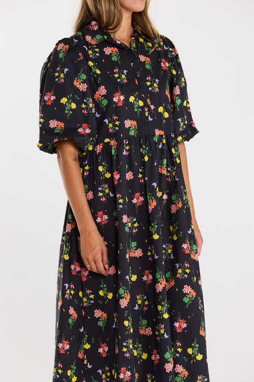 Woman wearing a black floral dress on a white background