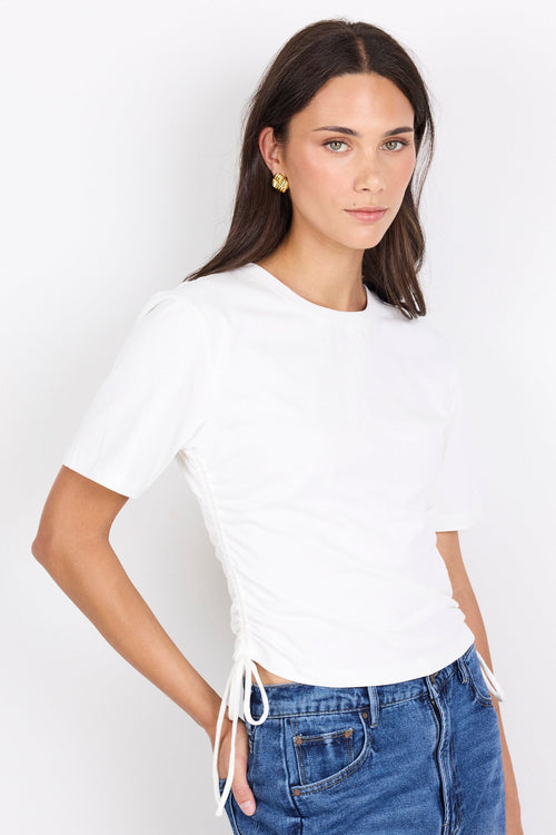 Woman wearing a white t-shirt and blue jeans on a white background