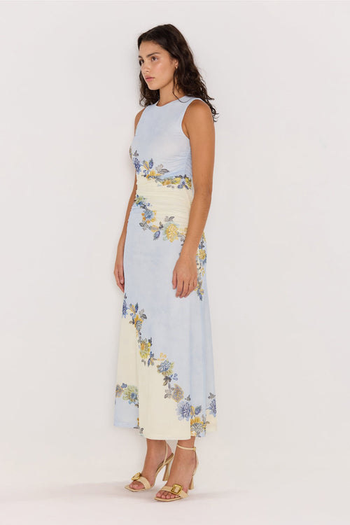 Woman wearing a sleeveless dress with floral pattern on a white background