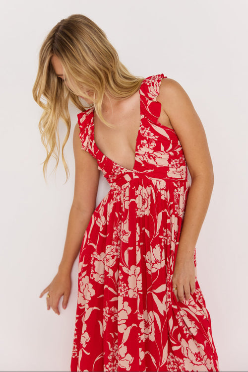 Woman wearing a red floral dress against a white background