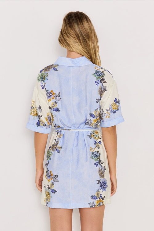 Woman wearing a light blue floral dress against a white background