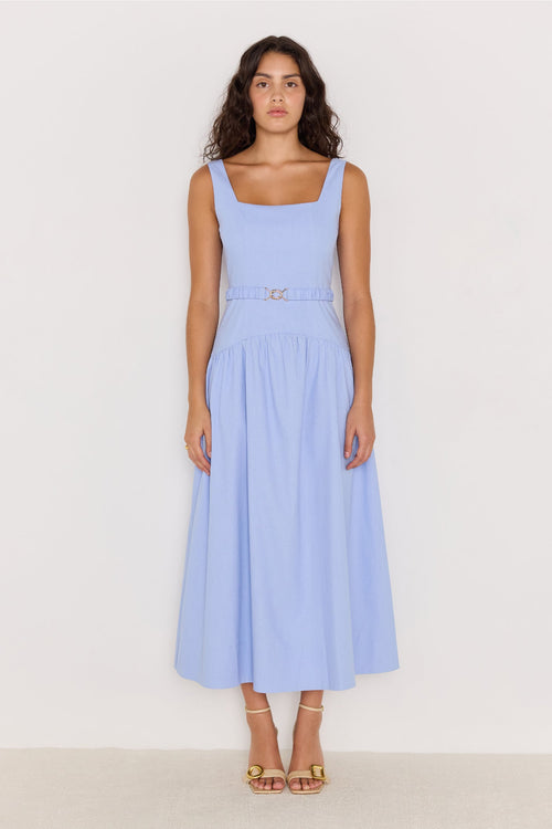 Woman wearing a light blue dress against a white background