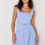 Woman wearing a light blue dress against a white background