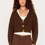 Woman wearing a brown cardigan and pants on a white background