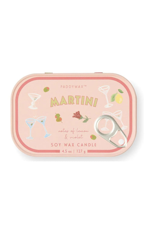 A Paddywax Martini soy wax candle in a pink metal tin with a pull-tab lid, decorated with cocktail glasses, olives, a lemon, and a rose illustration.