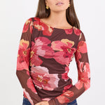 Woman wearing a floral long-sleeve top with a white background