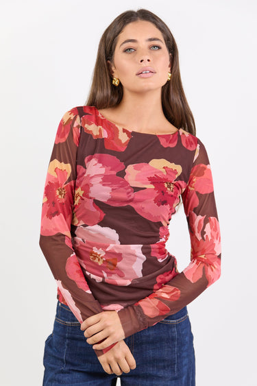 Woman wearing a floral long-sleeve top with a white background
