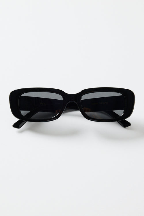 Glossy black rectangular sunglasses with dark tinted lenses, photographed on a white background.
