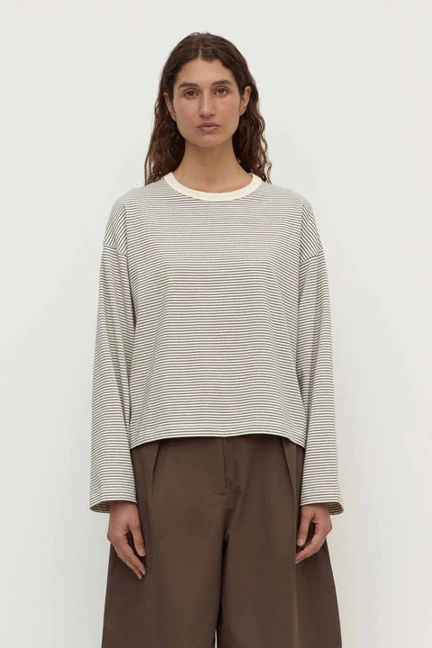Person wearing a striped shirt and brown pants against a white background