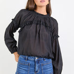 Women wearing black blouse with blue jeans.