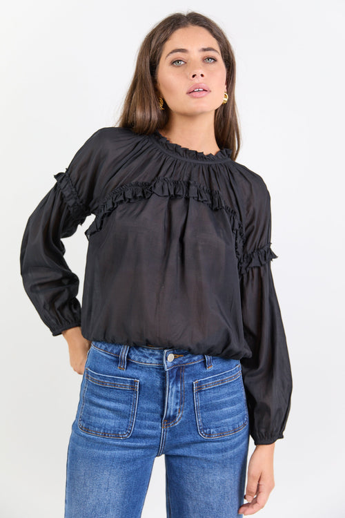 Women wearing black blouse with blue jeans.