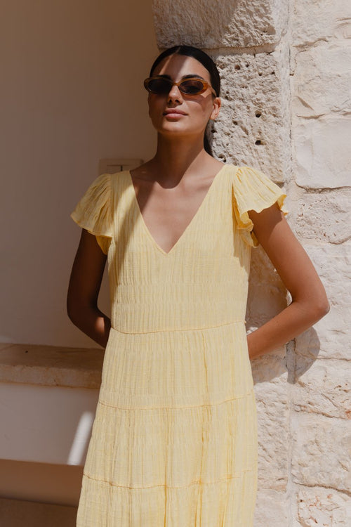 model wears a yellow flutter sleeve midi dress