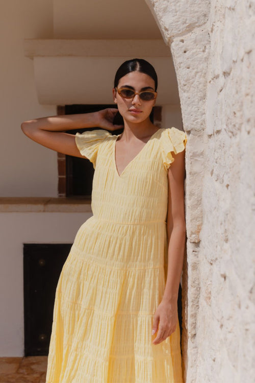 model wears a yellow flutter sleeve midi dress