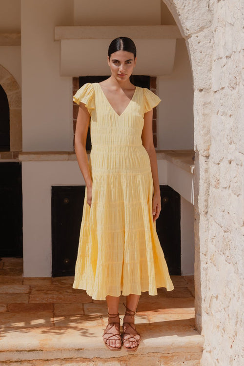 model wears a yellow flutter sleeve midi dress