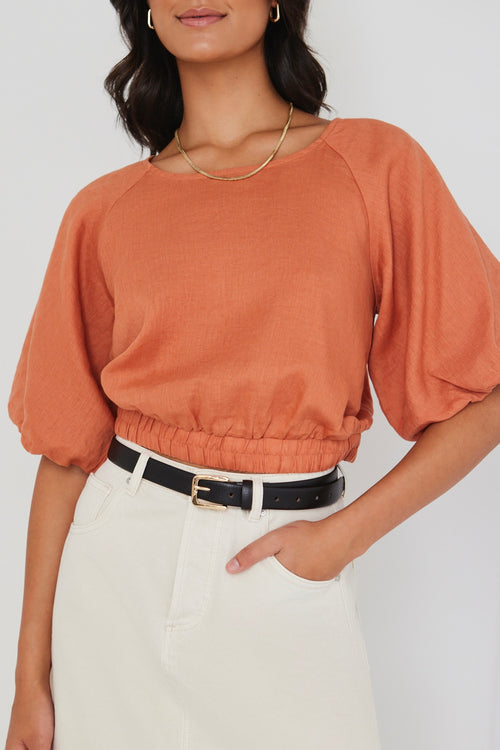 model wears an orange linen top